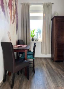 a dining room with a table and chairs and a window at Ferienwohnung Auszeit in Chemnitz