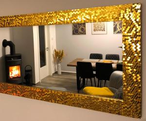 a mirror reflecting a dining room with a table and a fireplace at Ferienwohnung Auszeit in Chemnitz