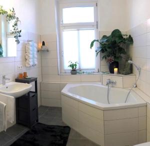 a white bathroom with a tub and a sink at Ferienwohnung Auszeit in Chemnitz