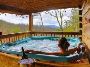 セバービルにあるRustic Cabinの小屋のホットタブに横たわる女