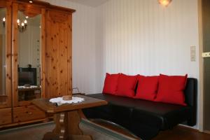 a living room with a black couch with red pillows at family & friends in Wernigerode