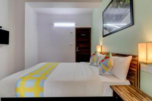 1 dormitorio con 1 cama blanca grande con almohadas coloridas en Home Exotic Stay Bsk 3rd Stage, en Bangalore