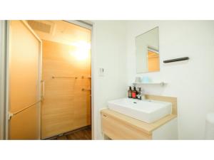 bagno con lavandino bianco e doccia di ELE HOTEL KUZUHA- Vacation STAY 80313v a Hirakata