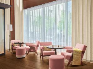 a room with pink chairs and tables and a large window at The Tokyo EDITION, Ginza in Tokyo