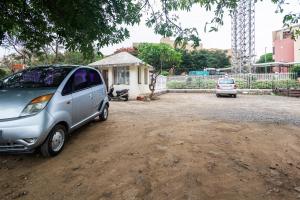 una pequeña camioneta plateada estacionada en un lote de tierra en Treebo Premium Niraali Executive, en Pune