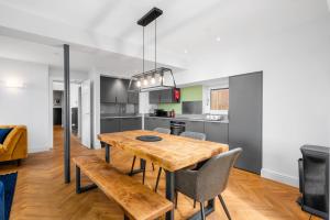 a kitchen and dining room with a wooden table and chairs at 312 Reids Corner - by StayDunfermline in Dunfermline