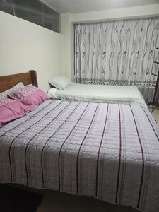 a bedroom with a bed with a striped blanket at PEPE´S HOUSE in Puno