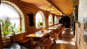 a row of wooden tables in a room with windows at Kwatery u Papieżów in Biały Dunajec