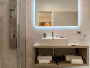 bagno con lavandino e specchio di Galleria Roma Art Guesthouse a Oristano