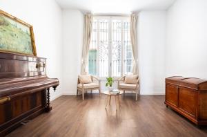 a living room with a piano and two chairs at Divino Hotel Boutique in Sitges