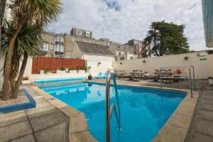 een zwembad met blauw water voor een gebouw bij Eliot Hotel in Newquay