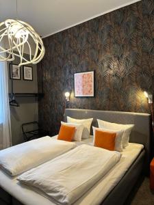 um quarto com uma cama grande e almofadas laranja em Hotel Maxplatz em Hof