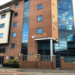 un bâtiment en briques avec un panneau devant lui dans l'établissement Legacy Preston International Hotel, à Preston