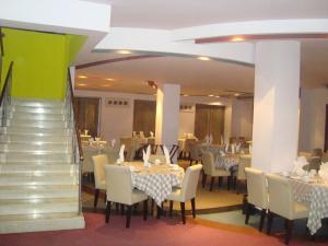 une salle à manger avec des tables et des chaises et un escalier dans l'établissement Nirvana Inn, à Sylhet