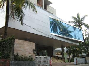 un bâtiment avec une façade en verre et des palmiers dans l'établissement Nirvana Inn, à Sylhet