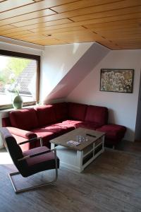 uma sala de estar com um sofá vermelho e uma mesa em Ferienwohnung Wegmann em Borkum