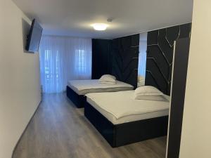 een kamer met 2 bedden en een televisie. bij CAMERE de INCHIRIAT LA TUGUIATA in Buşteni