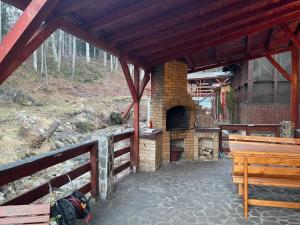 een patio met een bakstenen oven en een houten bank bij CAMERE de INCHIRIAT LA TUGUIATA in Buşteni