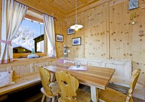 comedor con mesa de madera y sillas en Mahlknechthuette Seiseralm, en Alpe di Siusi