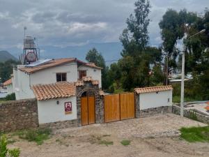 uma pequena casa com um portão e um farol em Lodge El Portal de Qopuy em Coporaque