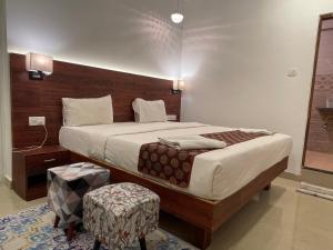 a bedroom with a large bed with a wooden headboard at Baga Keys by RJ14 in Old Goa