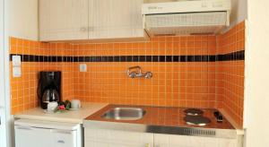 una cocina con fregadero y una pared de azulejos de color naranja en Villa Nefeli Skiathos, en Skiathos