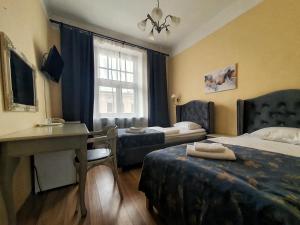 una camera d'albergo con 2 letti e una scrivania di Viktorija a Riga