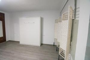 Habitación con puerta blanca y suelo de madera. en Loft Centro Huelva, en Huelva