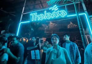 a group of people standing in front of a neon sign at Baga Keys by RJ14 in Old Goa