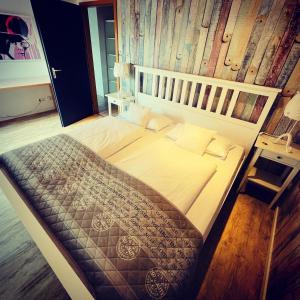 a large bed in a bedroom with a wooden wall at Zum Rayers Café-Restaurant & Boutique-Hotel 