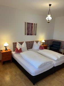 a bedroom with a large bed with white sheets and pillows at Cicáskacus Vendégház in Matrafured