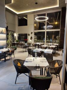 een restaurant met tafels, stoelen en ramen bij Domo Apuliae Aparthotel in Bari