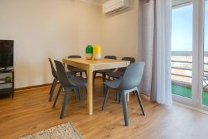 - une table et des chaises dans une chambre avec fenêtre dans l'établissement Ericeira Beach Apartment, à Ericeira