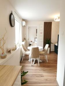 a white living room with a table and chairs at Apartman Bonsai in Subotica