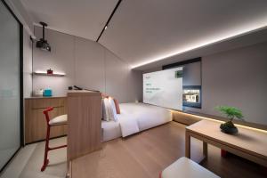 una camera con letto, scrivania e tavolo di SSAW Garden Hotel Beijing a Pechino