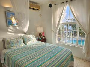 um quarto com uma cama e uma grande janela em Blue Topaz em Ocho Rios