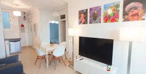 ein Wohnzimmer mit einem Flachbild-TV an der Wand in der Unterkunft Bayuca 107 Yumbo Center By Pride Holiday Rentals in Maspalomas