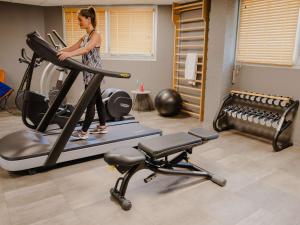 Una mujer caminando en una cinta de correr en un gimnasio en Mercure Le Havre Centre Bassin Du Commerce, en Le Havre