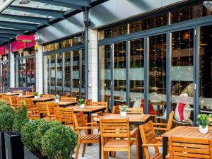 un restaurante con mesas y sillas de madera frente a un edificio en ibis Bristol Centre en Bristol