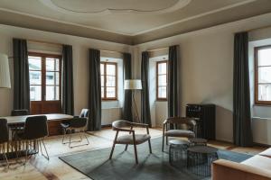 Arthotel Lasserhaus - adults only في Brixen: غرفة معيشة مع طاولة وكراسي