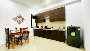 a kitchen with a table and chairs and a refrigerator at ZEN Suites - Golf Course Road Gurgaon in Gurgaon