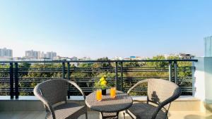 a table and chairs on a balcony with a view at ZEN Suites - Golf Course Road Gurgaon in Gurgaon