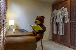 um urso de peluche sentado numa secretária com um livro em Sunny Cuddles em Canggu