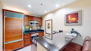 uma cozinha com armários de madeira e uma bancada em LADY LUCK'S VISTA - Private Balcony - Full Kitchen - Two Full Baths - Jetted Tub - Full MGM Grand Resort Access w No Resort Fee at MGM Signature em Las Vegas