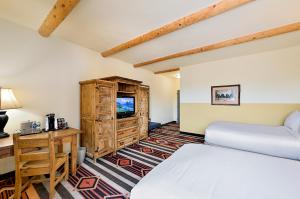 a bedroom with a bed and a desk and a tv at The Lodge at Santa Fe in Santa Fe