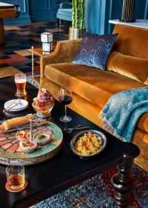 un tavolino da caffè con bicchieri da cibo e vino su un divano di Bowie House, Auberge Resorts Collection a Fort Worth