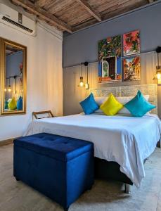 een slaapkamer met een groot bed met blauwe en gele kussens bij Maloka Boutique Hostel in Cartagena