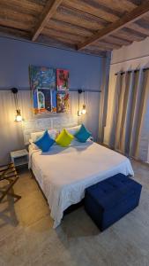 een slaapkamer met een groot bed met blauwe en gele kussens bij Maloka Boutique Hostel in Cartagena