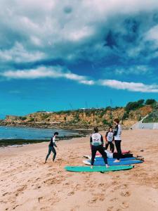 un grupo de personas de pie en tablas de surf en la playa en Turismo do Seculo, en Estoril