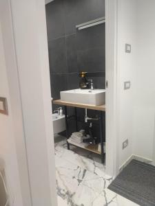 y baño con lavabo blanco y encimera. en A Casa Mia 2.0, en Saronno